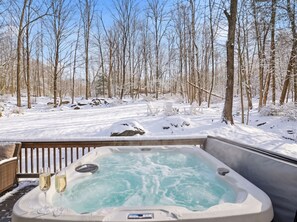 A hot tub surrounded by a snowy forest. - Spa-Style Luxury Lodge w/ Sauna, Hot Tub & Games (Tannersville)