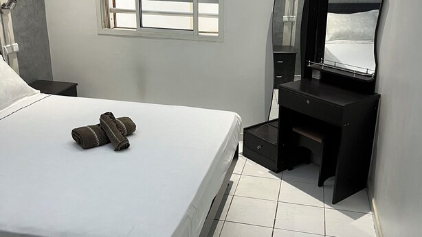 A modern bedroom with a large bed, a desk, and a mirror. - Premium Apartment | 5 Min from Rabat-Salé Airport | Free Parking & WiFi (Sale)