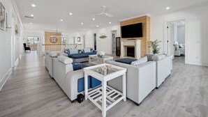 Un salon spacieux avec un grand canapé d’angle, une table basse et une cheminée.