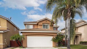 A residential house with a garage, palm trees, and a well-maintained lawn. - Perfect Family Home w/ Private Outdoor Space! (San Diego)