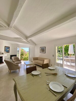 A dining area with a table set for four, a sofa, and a television. - Villa Bella – Secure Domaine de la Croisette, Gulf of Saint-Tropez View (Sainte-Maxime)