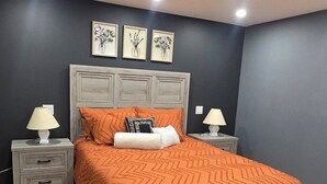 A bedroom with a bed, two nightstands, and three wall-mounted picture frames. - Modern country house w/firepit. (Alma)