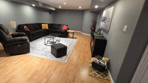 A modern living room with a sectional sofa, a recliner, a coffee table, and a small side table. - Modern country house w/firepit. (Alma)