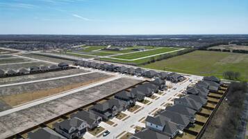 Vista aérea de uma área residencial com várias casas, ruas e áreas verdes.