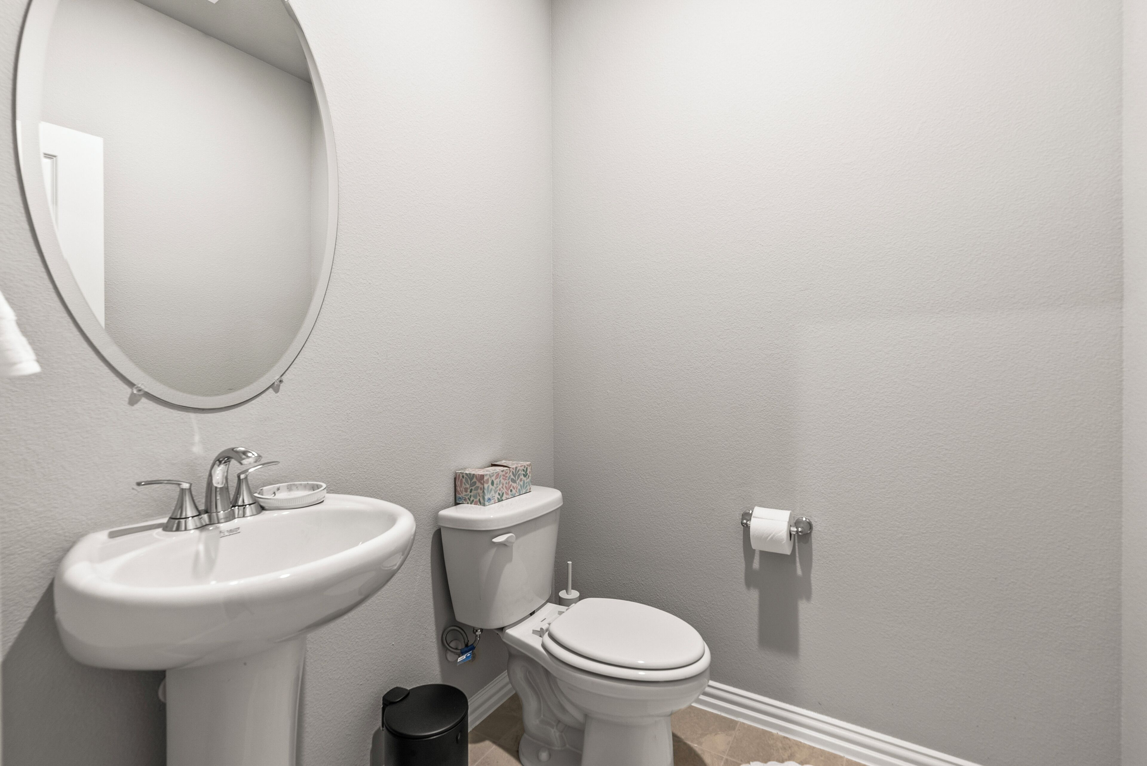 A bathroom with a sink, toilet, and mirror.