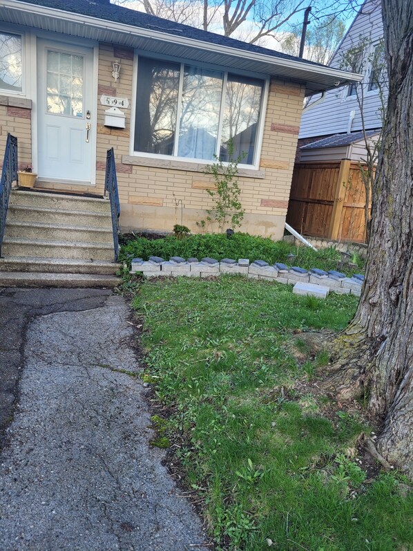 A residential house with a front porch, a mailbox, and a small lawn. - Clean, quite, comfortable home away from home, 20 mins to Niagara Falls Casino. (Welland)