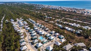 An aerial view of a resort with multiple dome-shaped buildings, a swimming pool, and a beach in the background. - 7029- Family Friendly - Gulf Shores - Pools-beach (Gulf Shores)