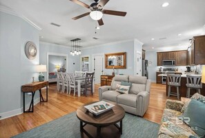 A spacious living room with a sofa, coffee table, and dining area. - 7029- Family Friendly - Gulf Shores - Pools-beach (Gulf Shores)