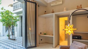 A modern living room with a checkered floor, a star-shaped lamp, a sofa, and a small table with a tissue box. - Suites and Spa - BY XO Riad (Marrakech)