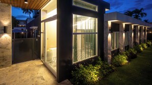 A modern building with large windows, a covered outdoor area, and a well-lit entrance. - Portofino 4BD Suite Pool Resort Vibe (San Juan)