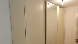 A room with a wooden floor, white walls, and a door with a light switch. - Retro Retreat! Reset-Recharge-Rewind (Bochum)