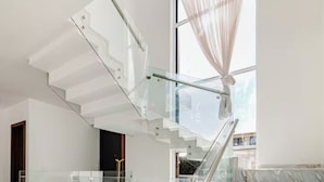 A modern staircase with glass railings and a view of the outdoors. - Private Pool • 4BR • 5.5 Baths • Secure • Upscale (Zapopan)