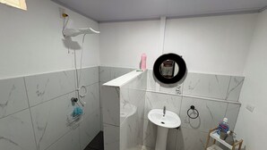 A bathroom with a sink, mirror, and shower area. - Floral Departments (Comunidad)