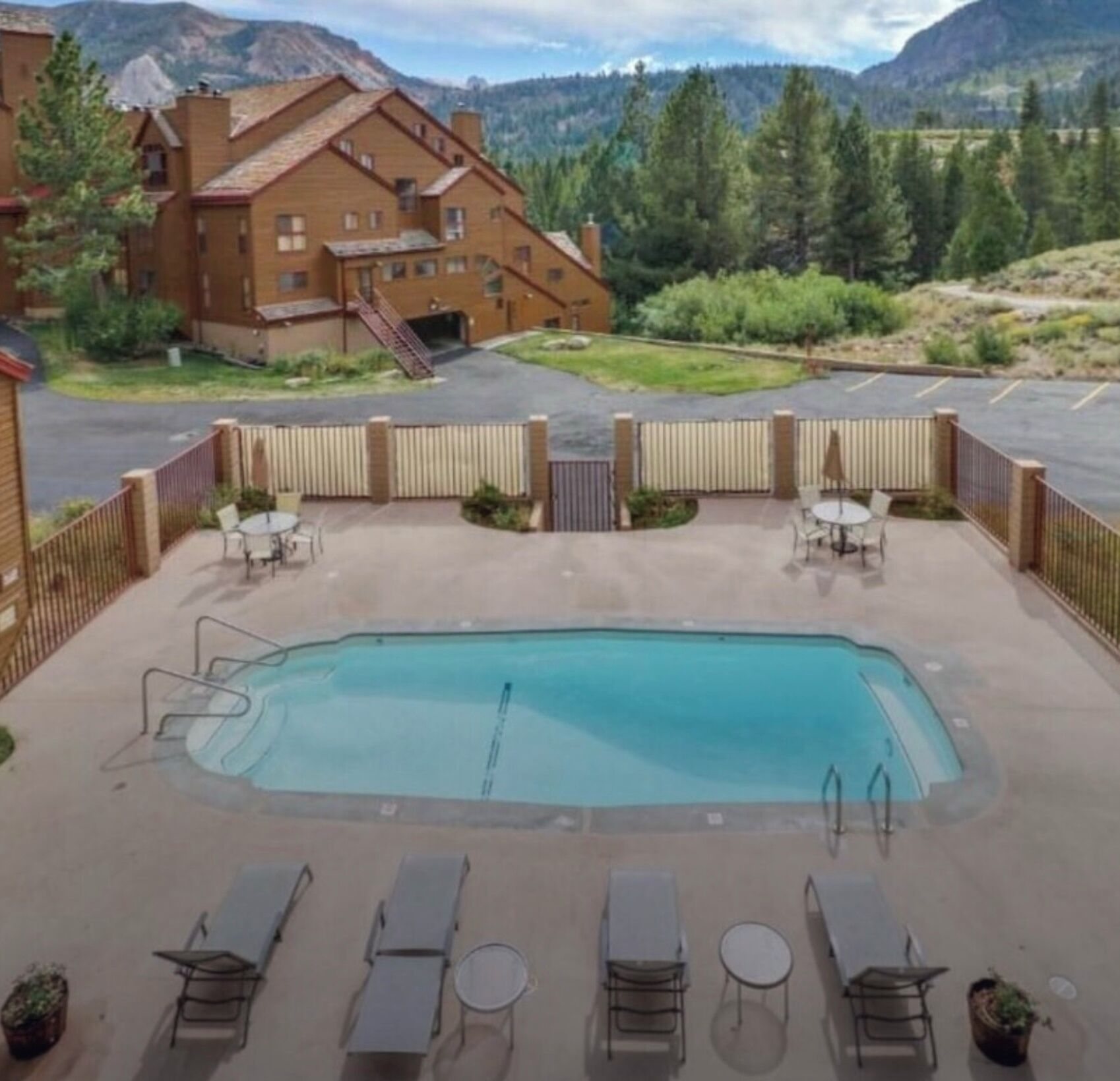 Un espace piscine doté de chaises longues et offrant une vue sur une chaîne de montagnes.