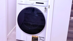 Lavadora y secadora de pared blanca con etiqueta ENERGY GUIDE que indica 608 kWh.