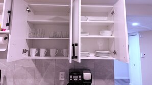Una cocina con alacenas abiertas que exhiben copas y platos.