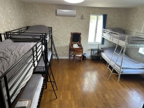 Un dormitorio con literas, un escritorio y una ventana.