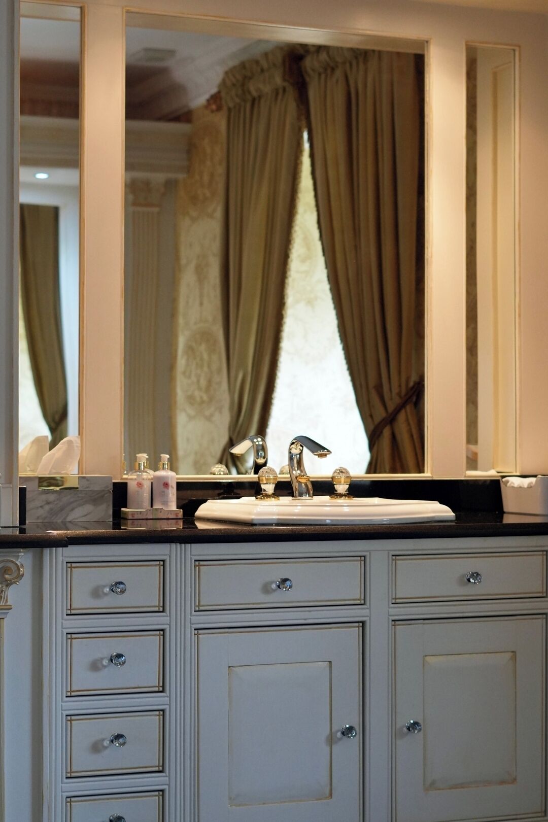 Un meuble-lavabo pour la salle de bain, doté d’un miroir, d’un évier et de plusieurs tiroirs.