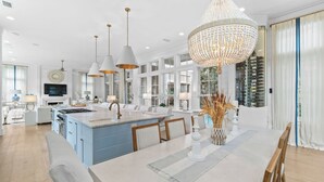 A spacious kitchen with a large island, pendant lighting, and a chandelier. - Camp District Luxury | Private Courtyard Pool | Electric Cart | Beach Club Access (Santa Rosa Beach)
