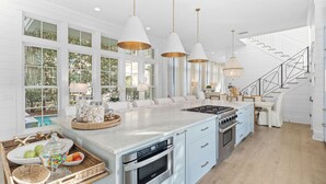 A spacious kitchen with a large island, stainless steel appliances, and pendant lighting. - Camp District Luxury | Private Courtyard Pool | Electric Cart | Beach Club Access (Santa Rosa Beach)