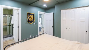 Un dormitorio con cama, ventilador de techo, ducha y un cartel en la pared.