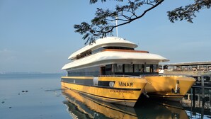 A large, yellow and white cruise ship docked at a pier with a calm sea and clear sky in the background. - Hotel Astro Marine (Kanayannur)