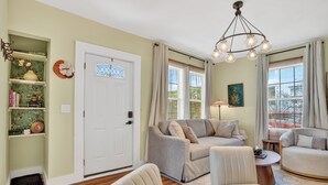 A living room with a sofa, armchairs, a coffee table, and a chandelier. - Magnolia Soul- Modern Southern Retreat (Macon)