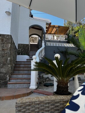 A staircase leading to a covered area with a white railing and a stone wall. - CostaBlancaDreams - Studio 44 in Benissa (Benissa)