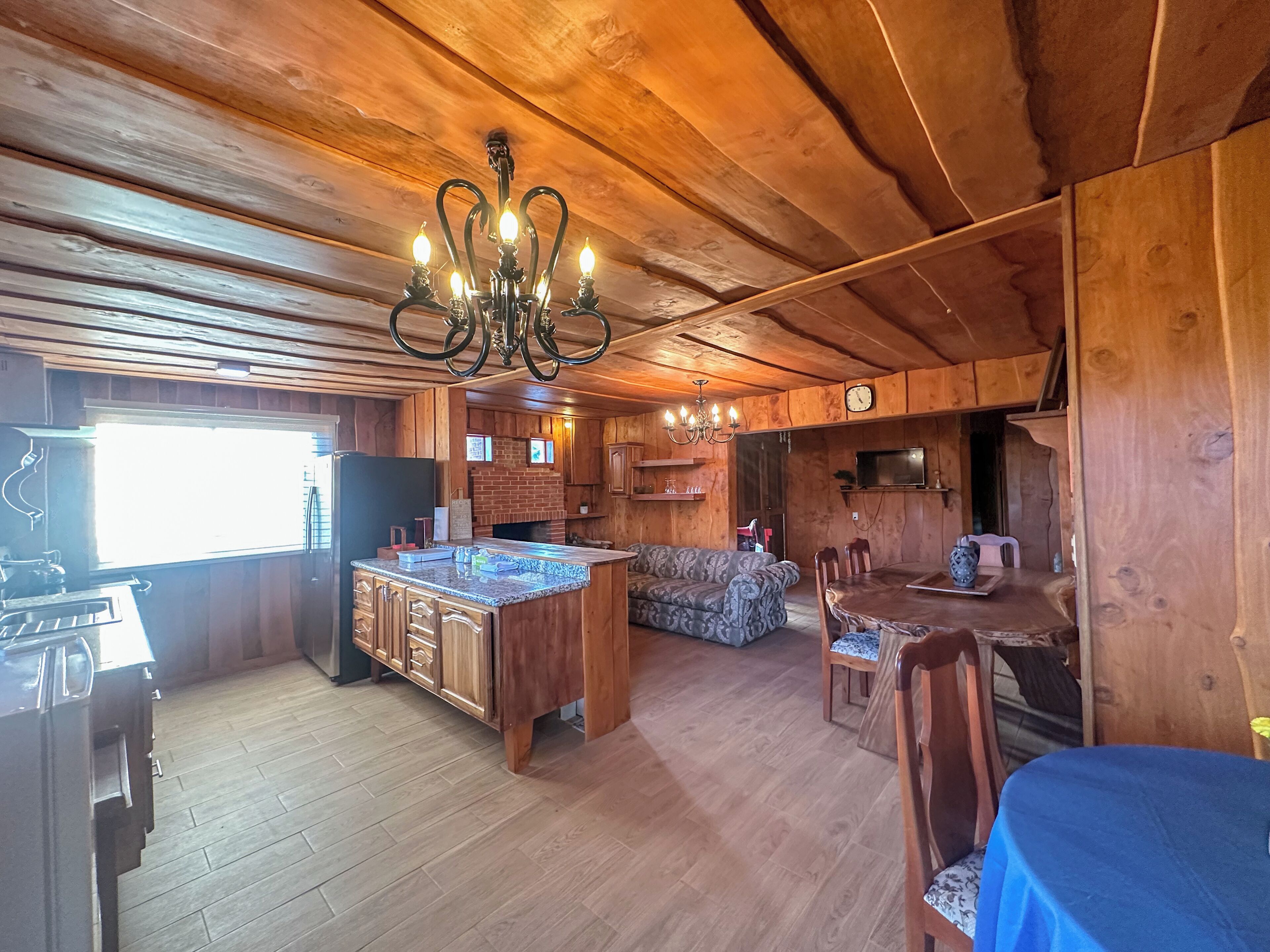 A wooden interior with a kitchen, dining area, and living space.