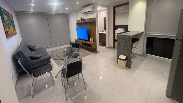 A modern living room with a sofa, TV, and dining area. - Beutiful one bedroom one bathroom fully equiped apartment on the best zone of sc (Santa Cruz de la Sierra)