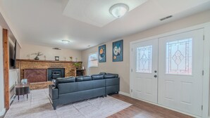 Una sala de estar con chimenea, un sofá modular, una mesa de centro y una alfombra.
