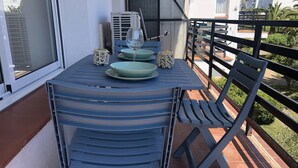 A balcony with a table set for two, a chair, and a view of the surrounding buildings. - AMSTERDAM. Exclusive Comfort on the Costa Brava (Roses)