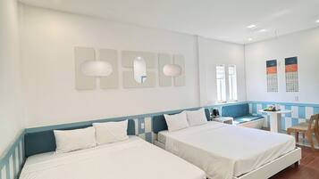 A hotel room with two beds, a small desk, and a chair.