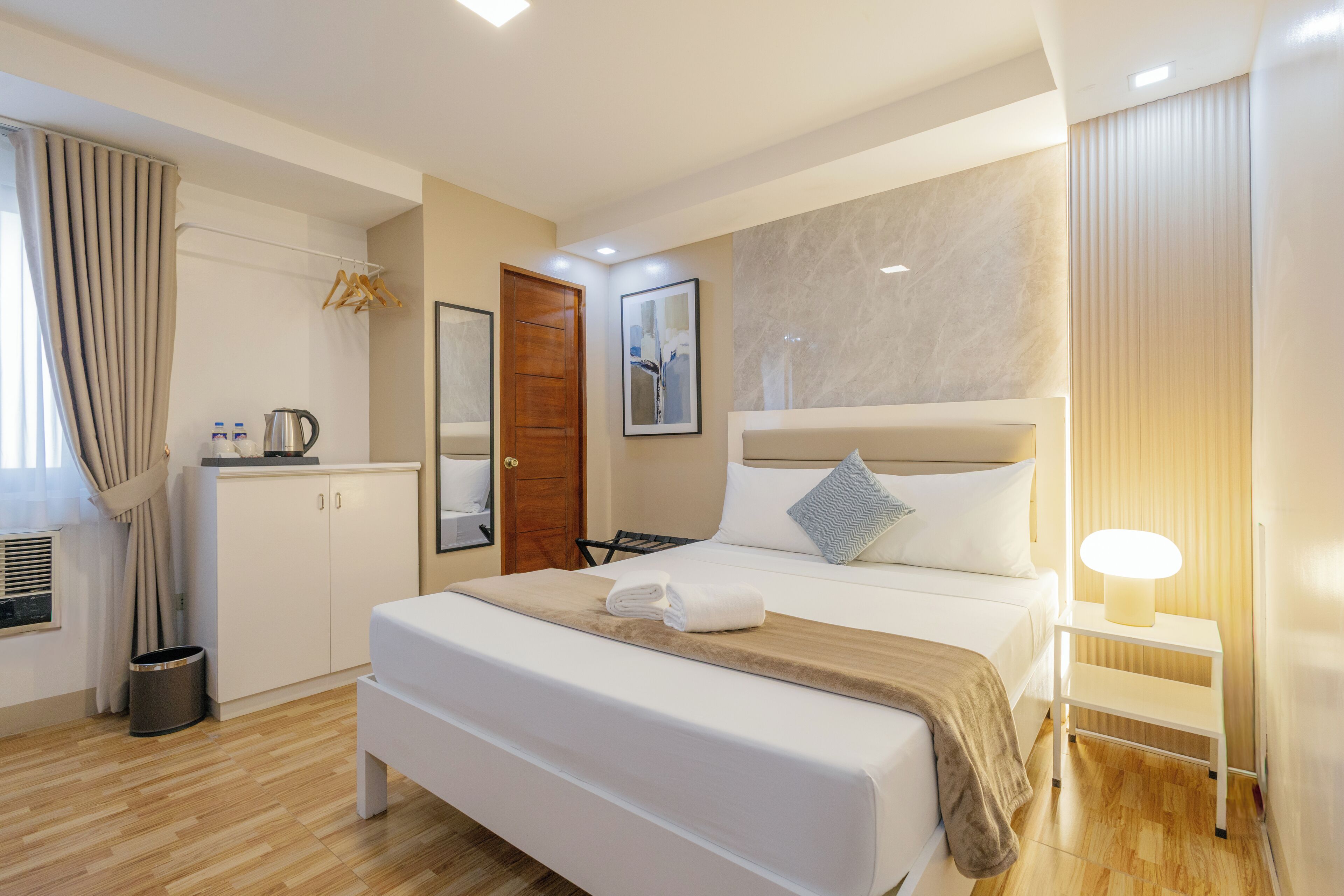 Una habitación de hotel con cama, mesita de noche y armario.