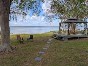 Ein Kiosk mit Blick auf das Wasser, zwei Stühle und ein Steinweg.