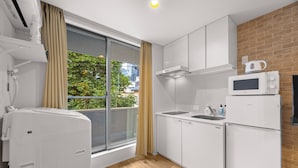 Una cocina moderna con gabinetes blancos, un microondas y un refrigerador.