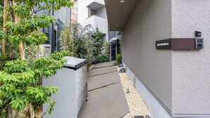 Un sendero estrecho que lleva a la entrada de un edificio, con un letrero que indica 'B&B APARTMENT'.