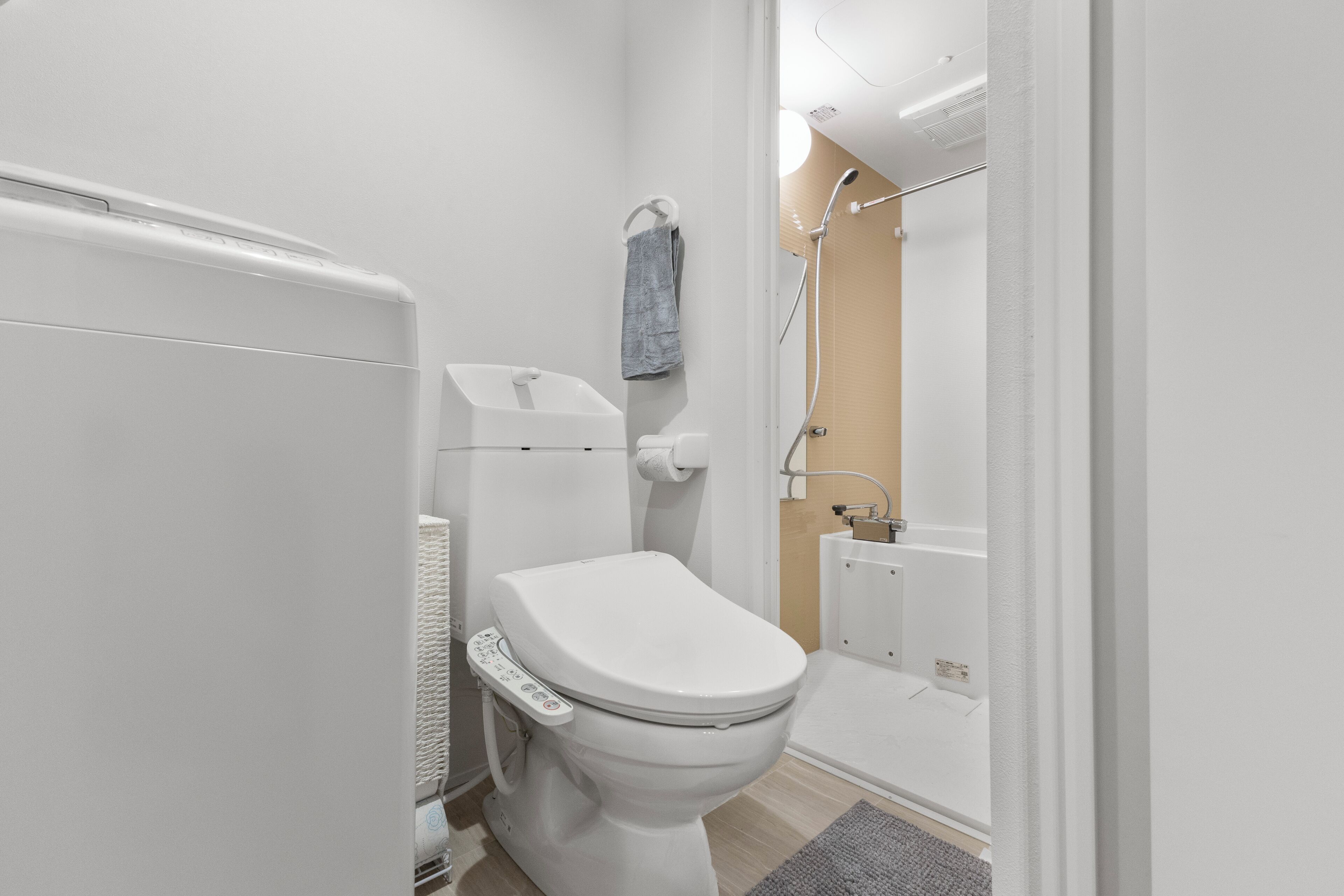A modern bathroom with a toilet, a towel rack, and a shower area.