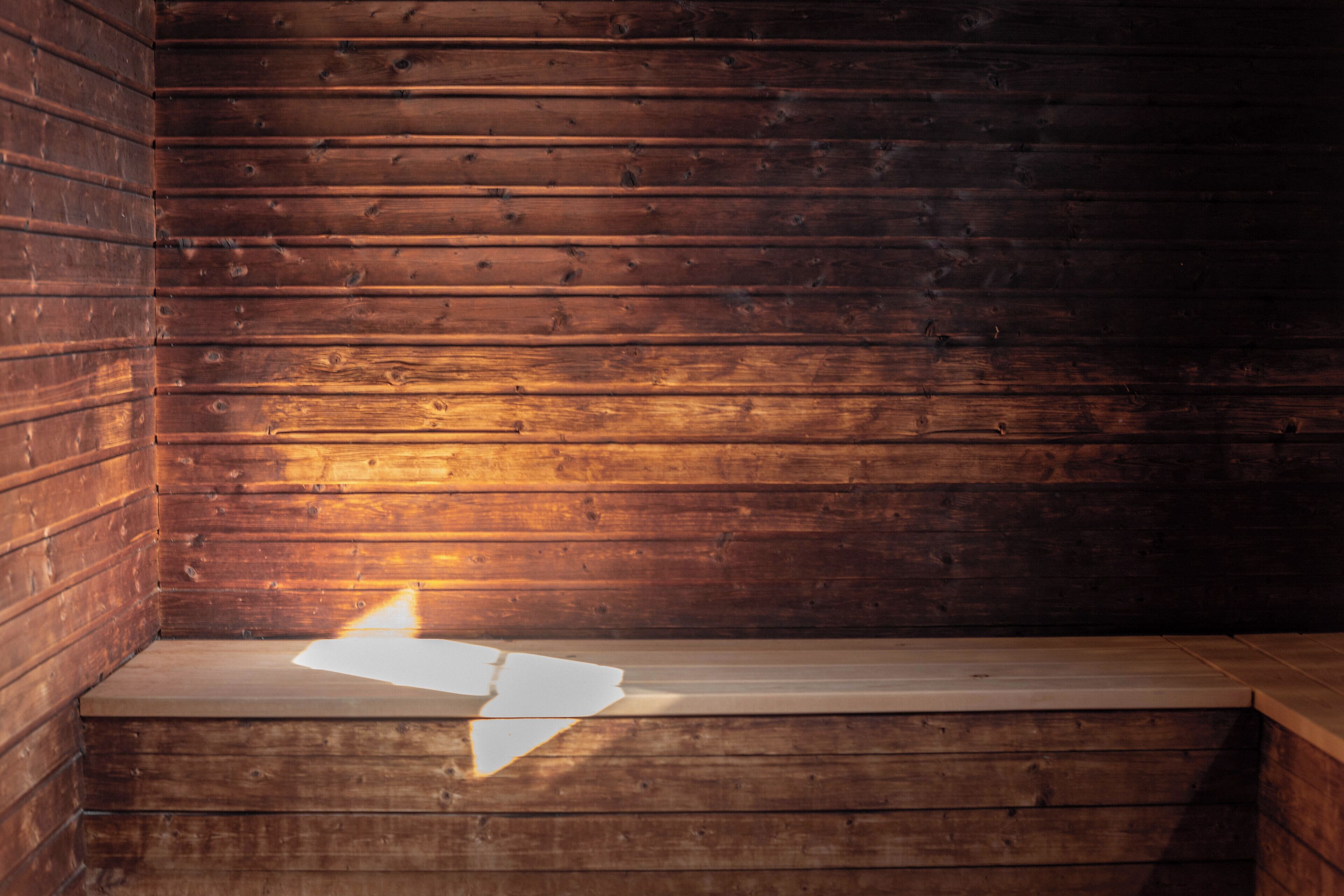 A wooden bench with a white object on it, set against a wooden wall.