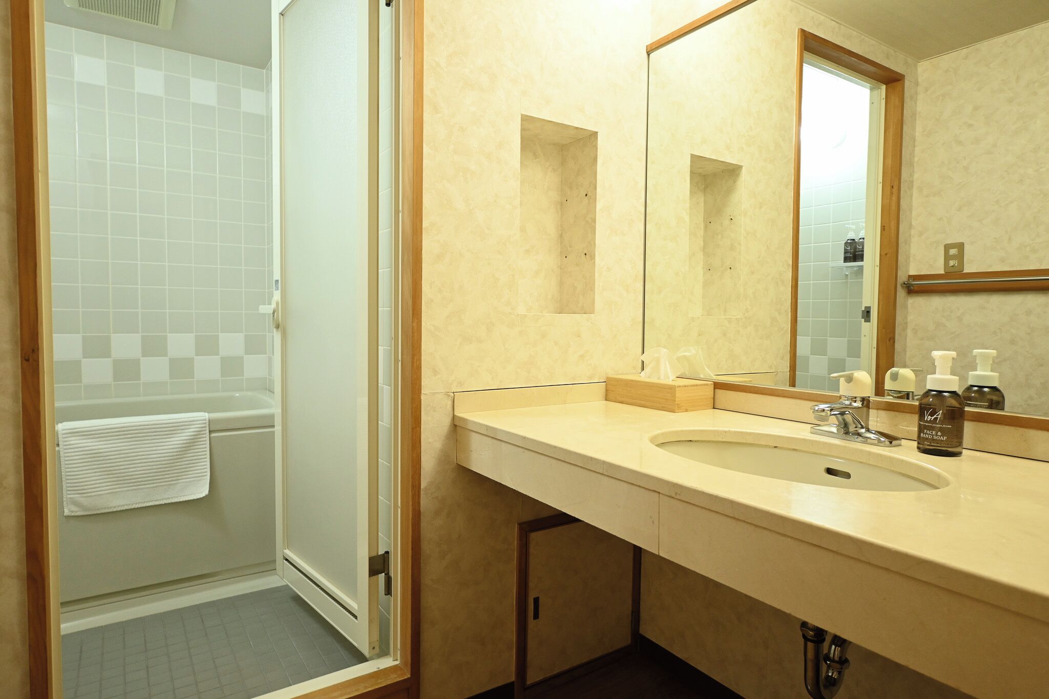 Un baño con bañera, lavabo, espejo y artículos de aseo.