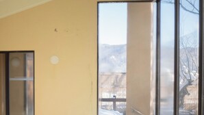 An indoor swimming pool with clear water, large windows, and a view of a snowy landscape. - Hotel Goryukan (Hakuba)