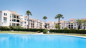 Een meerlaags hotel met een zwembad op de voorgrond.