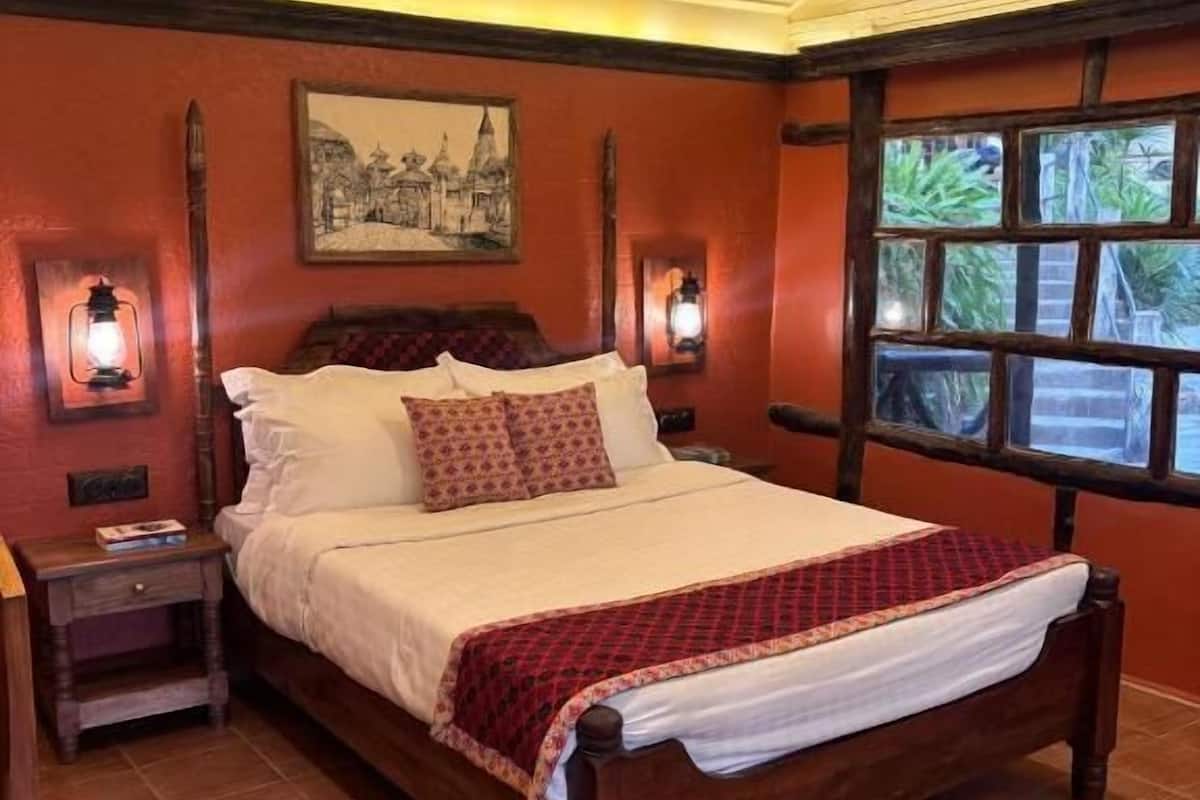 A bedroom with a wooden bed, two bedside tables, a nightstand, a large window with a view, and a ceiling fan.