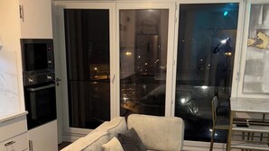 A modern living room with a sectional sofa, a glass coffee table, and a kitchen area with a microwave and oven. - 2. "Comfortable stay in Bagnolet - Ideally located near the Metro" (Bagnolet)