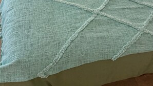 A bed with a green bedspread and a light blue blanket. - 2. "Comfortable stay in Bagnolet - Ideally located near the Metro" (Bagnolet)