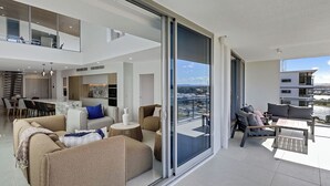 En moderne lejlighed med balkon, spiseområde og køkken.