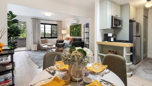 Un salon moderne comprenant un coin repas, une cuisine et un balcon.