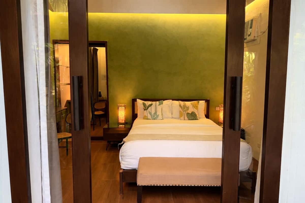 A bedroom with a bed, bedside table, and a chair.
