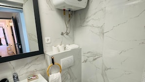 A modern bathroom with a marble backsplash, a white sink, a toilet, and a handheld bidet. - Stylish Couple Getaway Near Beach (Sukosan)