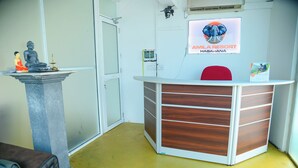 A reception desk with a wooden finish, a statue of Buddha, and a sign for Amila Resort Habahana. - Amila Resort (Habarana)
